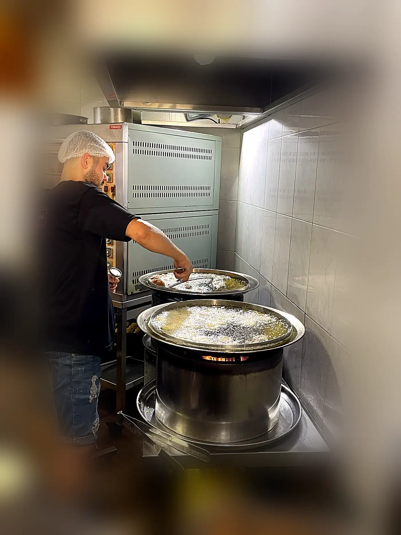 Falafel cooking in two wide pans at Falafel Al Mallah